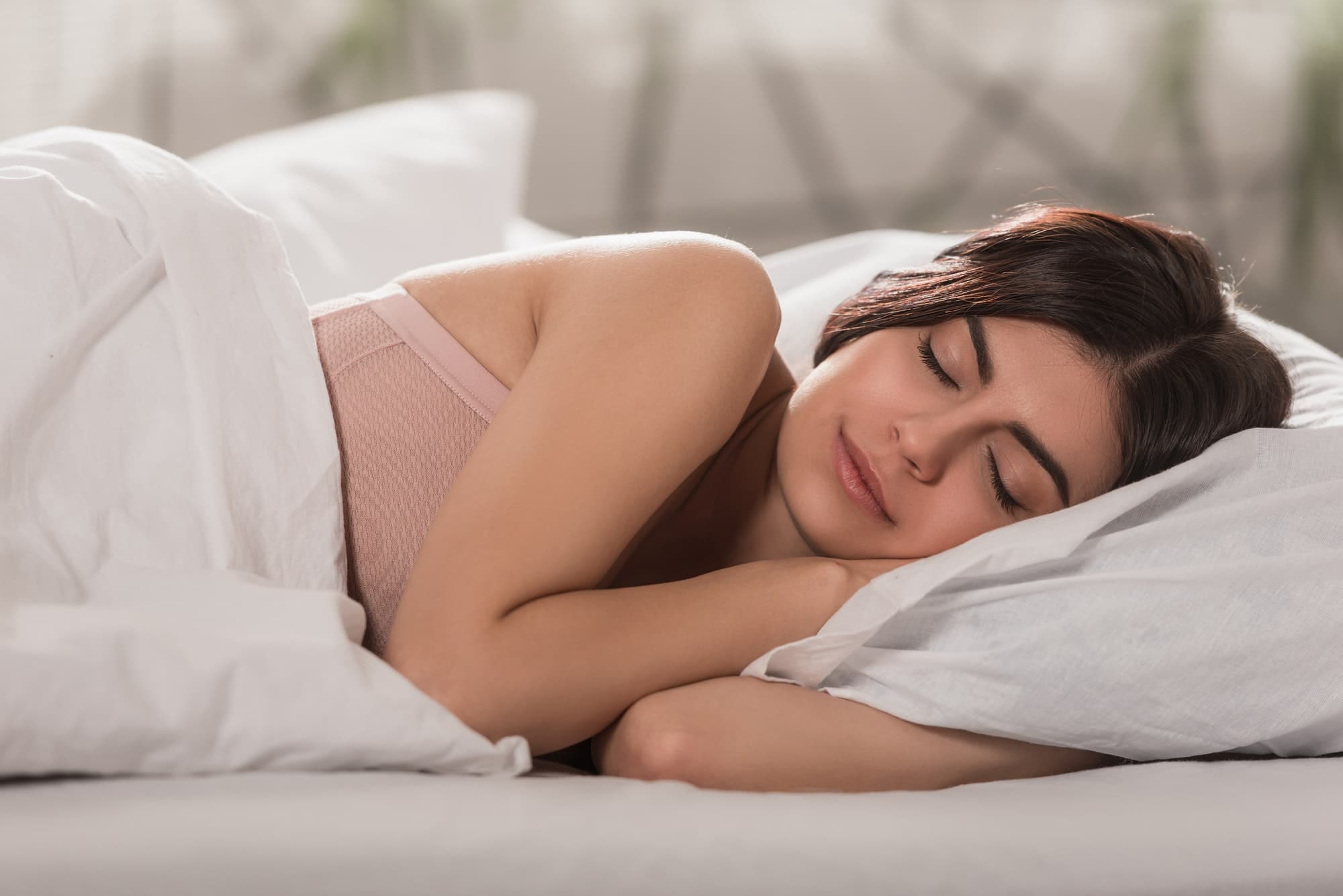 chica atractiva durmiendo en la cama en casa