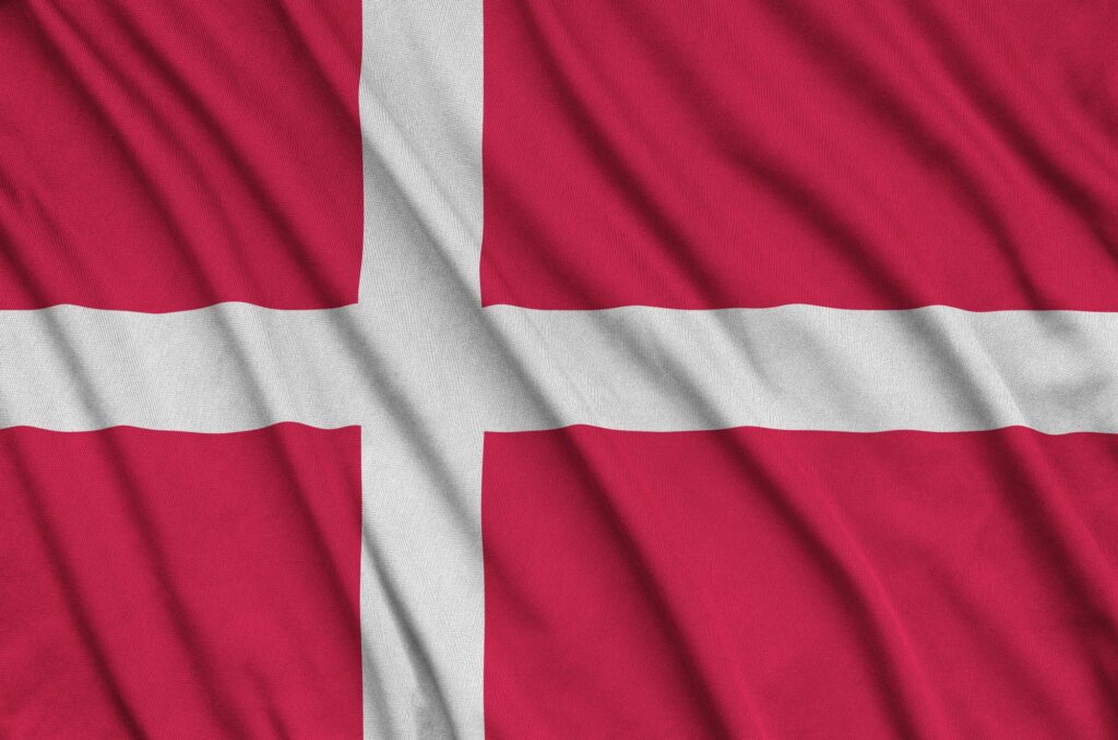 La bandera de Dinamarca está representada en una tela deportiva con muchos pliegues. Equipo deportivo agitando una pancarta