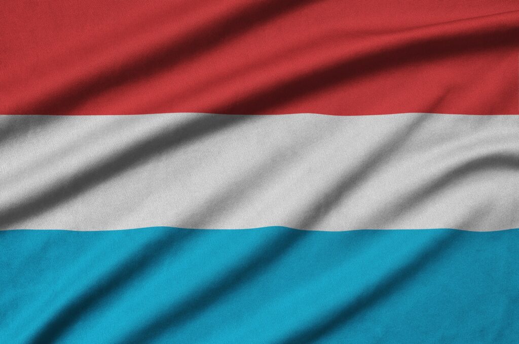 La bandera de Luxemburgo está representada en una tela deportiva con muchos pliegues. Equipo deportivo agitando una pancarta