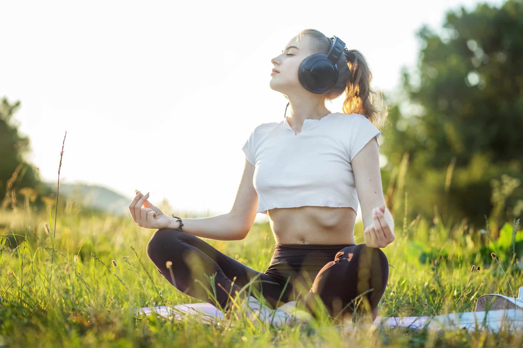 La chica escucha música con auriculares. Una mujer está meditando. Concepto de estilo de vida, música